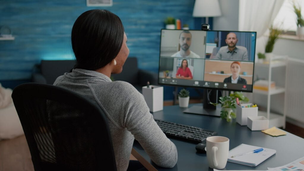 black student discussing marketing academic ideas with college team having virtual teleconference meeting sitting desk living room